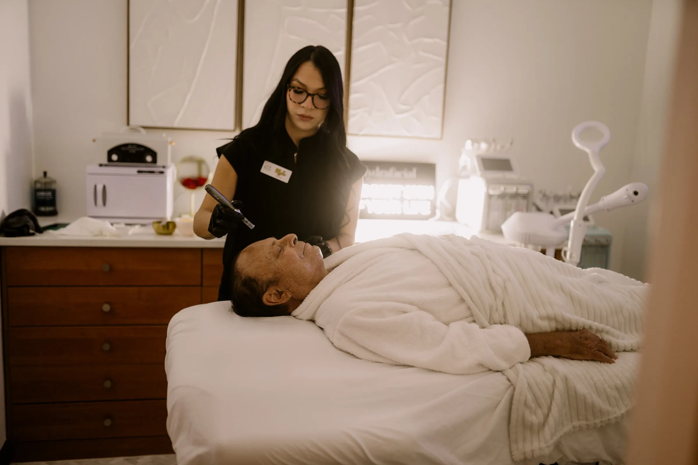 An esthetician performing a facial treatment in a Lift & Revive treatment room
