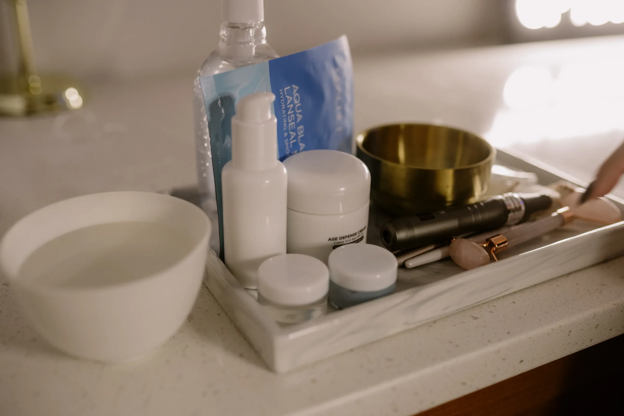 Skincare products and treatment tools arranged on a marble tray